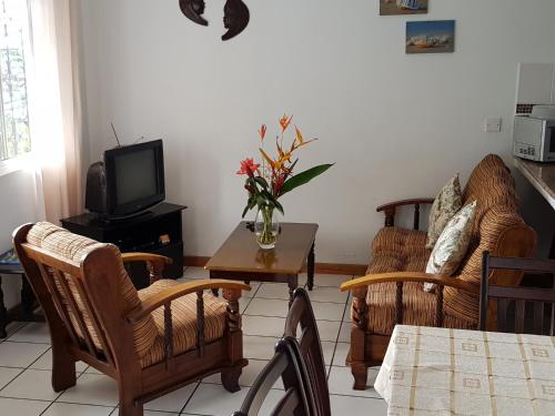 a living room with chairs and a table and a tv at Chepsted Chalets in Glacis