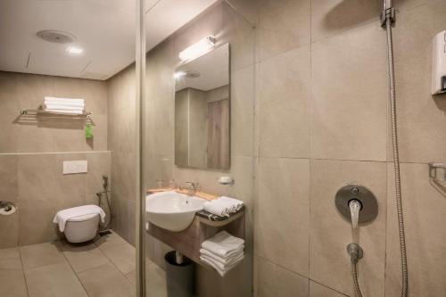 ein Bad mit einer Dusche, einem Waschbecken und einem WC in der Unterkunft Cititel Express Penang in George Town