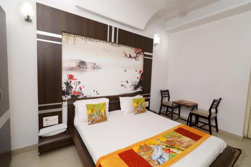 a bedroom with a bed and a table and chairs at The LEEF INN 500Ms from Nakki Lake in Mount Ābu