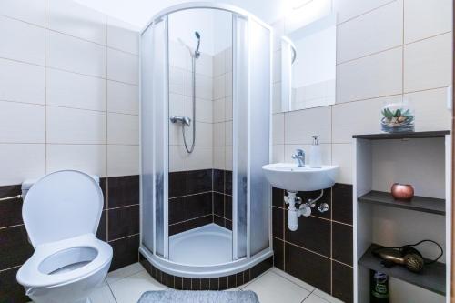 y baño con ducha, aseo y lavamanos. en Apartments Křenová Brno-center en Brno