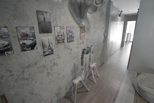 two skeletons on a wall with pictures on it at OK CHIC PHUKET HOSTEL in Phuket Town
