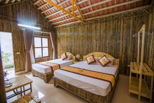 Un dormitorio con dos camas en una habitación. en Tam Coc The Moon Lady Homestay, en Ninh Binh