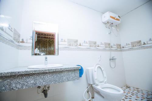 Un baño blanco con lavabo e inodoro. en Tam Coc The Moon Lady Homestay, en Ninh Binh