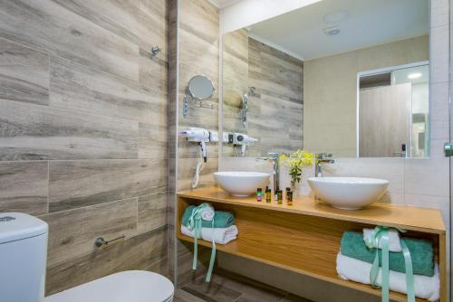 a bathroom with two sinks and a mirror at Incognito Creta Luxury Suites and More in Kolymvari