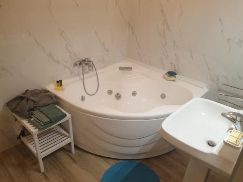 a white bathroom with a tub and a sink at Al 17 in Sturno