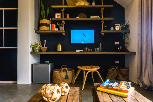 ein Wohnzimmer mit einem Tisch und einem TV an der Wand in der Unterkunft El Nido Boutique Vacation Villas in El Nido