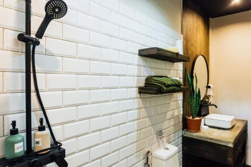 a bathroom with a white tiled wall at El Nido Boutique Vacation Villas in El Nido