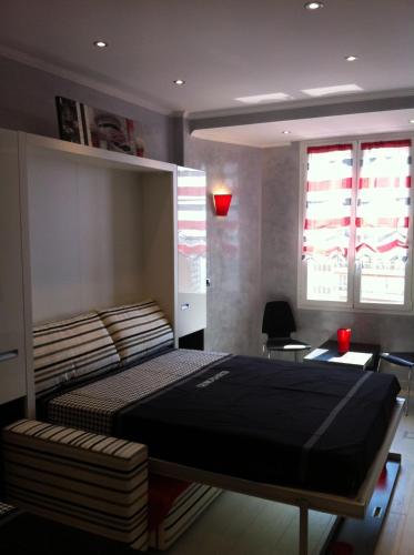 une chambre avec un lit, un bureau et des fenêtres dans l'établissement MONACO DREAM, à Beausoleil