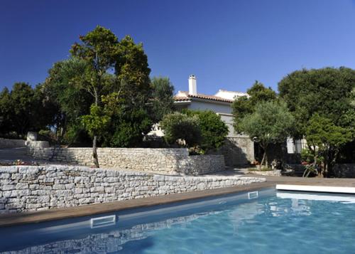 une maison avec un mur en pierre et une piscine dans l'établissement Casa Martini, à Bonifacio