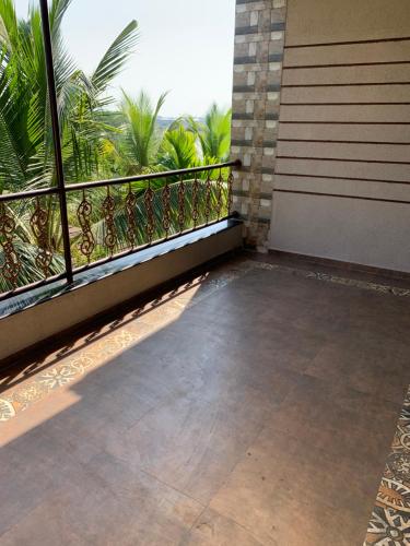 a balcony of a house with a view of palm trees at Neville's Villa - Pet friendly with Pool in Alibaug