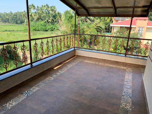 a balcony with a view of a field at Neville's Villa - Pet friendly with Pool in Alibaug
