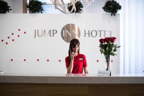 a woman talking on a cell phone on a counter at Jump INN Hotel Belgrade in Belgrade