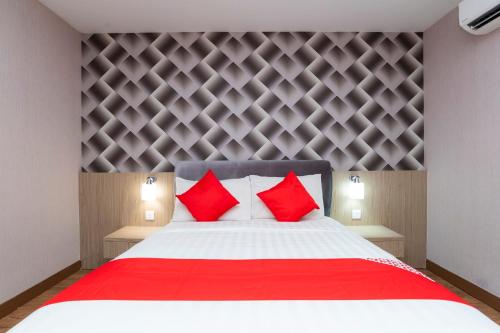 a bedroom with a large bed with red pillows at Hotel 101 Ulu Tiram in Ulu Tiram