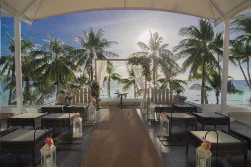 a restaurant with a view of the ocean and palm trees at The District Boracay in Boracay
