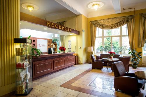 a waiting room with a reception desk and chairs at Polonia in Kudowa-Zdrój