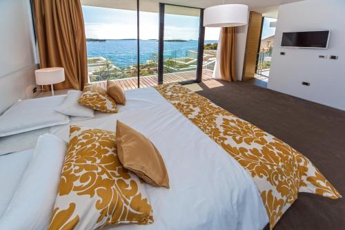 a bedroom with a bed with a view of the ocean at Golden Rays Luxury Villas & Apartments in Primošten