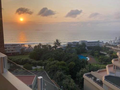 a view of the ocean at sunset from a building at 71 Sea Lodge Beachfront Apartment in Durban