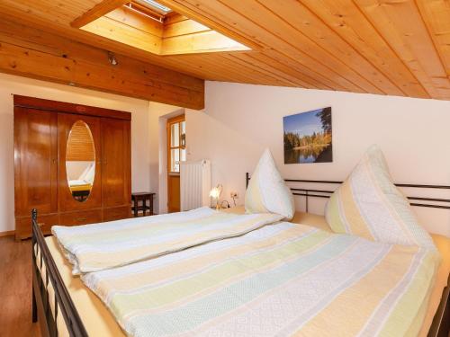 a large bed in a room with a wooden ceiling at Haus Koch-Lechner in Marquartstein