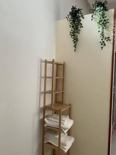 a wooden shelf with towels and plants on a wall at BnB Nonna Maria in Poggiomarino