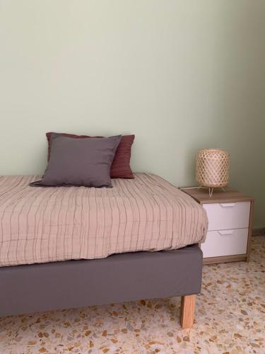 a bedroom with a bed and a nightstand with a pillow at BnB Nonna Maria in Poggiomarino