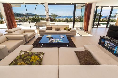 a living room with white couches and a tv at Golden Rays Luxury Villas & Apartments in Primošten