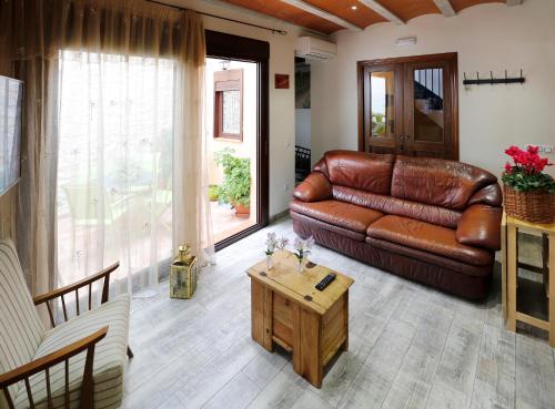 a living room with a leather couch and a coffee table at Cal Vibo in Vilabella