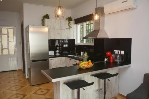 una cocina con nevera y un bol de fruta en una barra en Sunrise View Apartments en Barbati