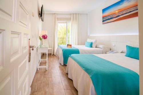 Habitación de hotel con 2 camas y ventana en Hotel Romerito en Málaga
