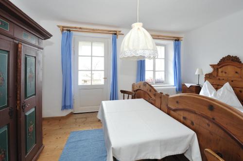 a room with a bed and a table and windows at Gasthof Simony Hallstatt B&B in Hallstatt