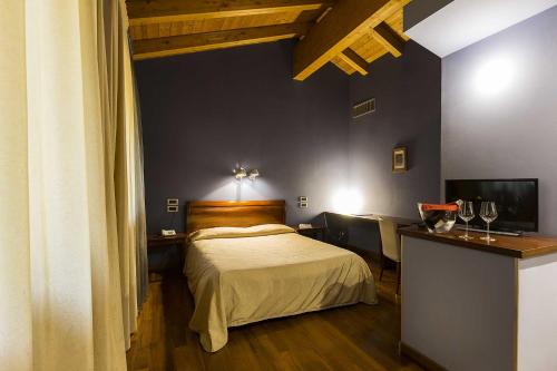 a bedroom with a bed and a television in it at Hotel Due Platani in Cornedo Vicentino