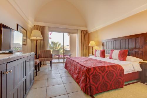 um quarto de hotel com uma cama e uma televisão em TUI MAGIC LIFE Kalawy em Hurghada