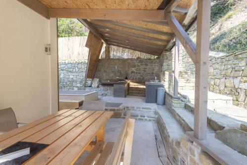 a patio with a wooden bench and a stone wall at Holiday Home Casa Salina in Sečovlje