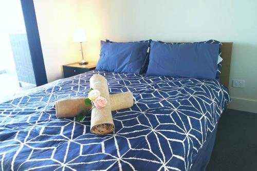 a bed with a pair of towels on it at Modern apartment+office w Parking @ Olympic Park in Sydney
