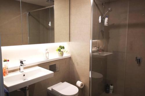 e bagno con servizi igienici, lavandino e doccia. di Modern apartment+office w Parking @ Olympic Park a Sydney