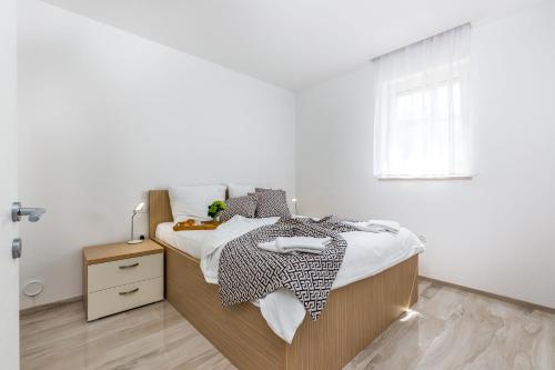 una camera bianca con un letto e una finestra di Luxury apartments Kostrena with pool 2 a Kostrena (Costrena)