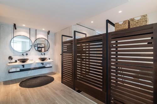 a bathroom with two sinks and two mirrors at Villa Chinka by Astor Garden Hotel - Adults Only in Saints Constantine and Helena