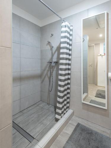 a bathroom with a shower with a black and white shower curtain at Holiday Home Casa Salina in Sečovlje