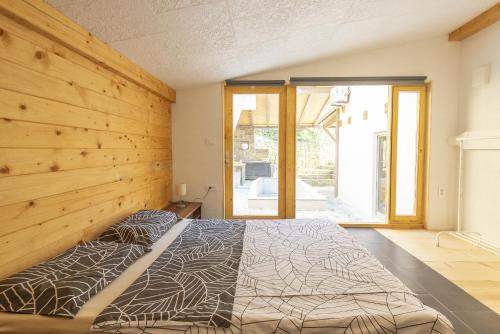ein Schlafzimmer mit einem Bett und einer Holzwand in der Unterkunft Holiday Home Casa Salina in Sečovlje