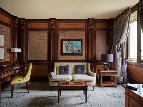 
a living room filled with furniture and a large window at Hotel Principe Di Savoia - Dorchester Collection in Milan
