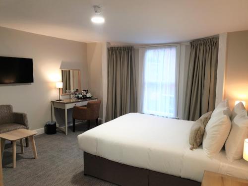 a hotel room with a large bed and a desk at The Merchant's House, BW Signature Collection in Salisbury