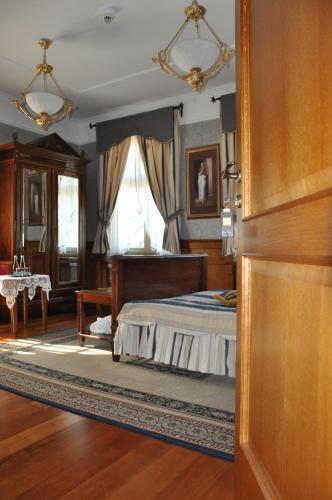 a bedroom with a bed and a table in it at Pałac Czarny Las (50 km od Katowic) in Woźniki