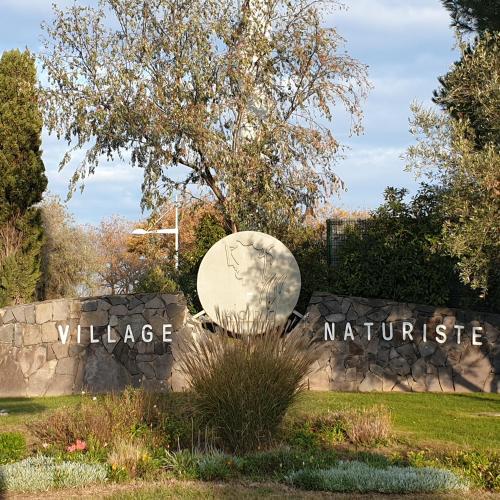 a sign for a wildlife village sign in a park at 2Cap d'Agde NATURISTE Grand T2 de standing avec GARAGE privé in Cap d'Agde
