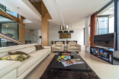 a living room with a couch and a tv at Golden Rays Luxury Villas & Apartments in Primošten