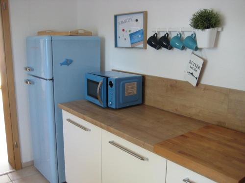un forno a microonde seduto su un bancone accanto a un frigorifero blu di Ferienhaus "Strandgut" a Ueckermünde