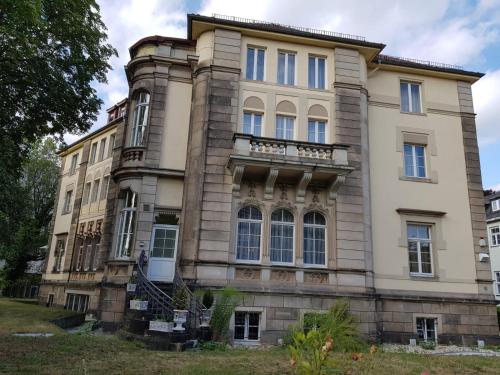 un ancien bâtiment avec un escalier devant lui dans l'établissement Hotel-Villa Lalee, à Dresde