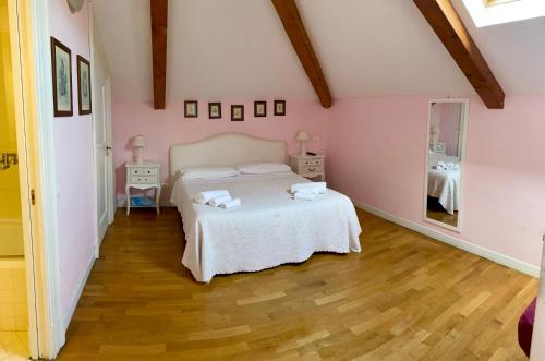 a bedroom with a white bed and a pink wall at The Secret Garden Relais in Piano di Sorrento