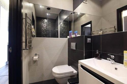 ein Bad mit einem WC, einem Waschbecken und einer Dusche in der Unterkunft Apartment Ruska Street in Lwiw