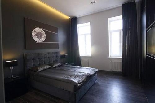 ein Schlafzimmer mit einem Bett und zwei Fenstern in der Unterkunft Apartment Ruska Street in Lwiw