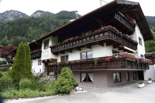 ein Gebäude mit Blumen auf den Balkonen in der Unterkunft Gästehaus Gisela in Bruck am Ziller
