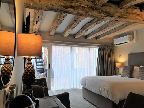 a hotel room with a bed and a large window at The Merchant's House, BW Signature Collection in Salisbury